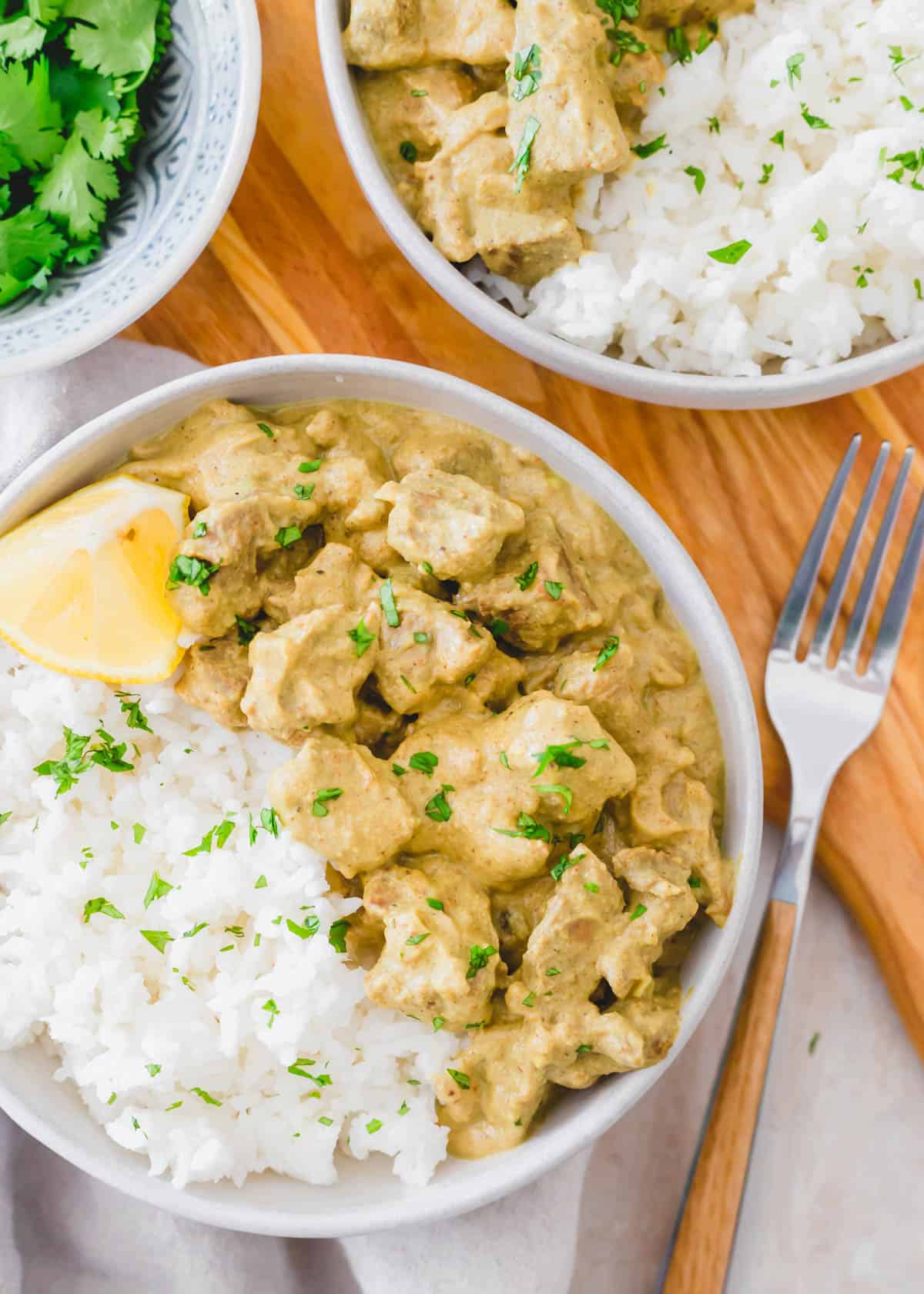 Lamb korma recipe served with white rice in a bowl.