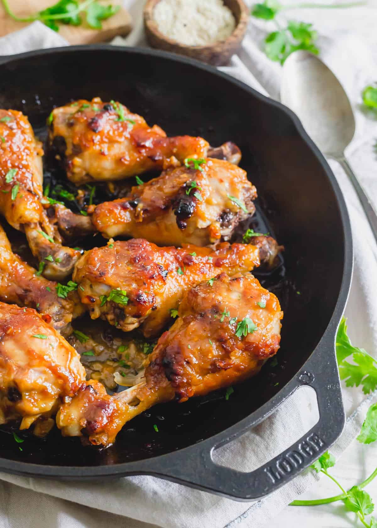 Maple miso glazed chicken drumsticks baked in a cast iron skillet.