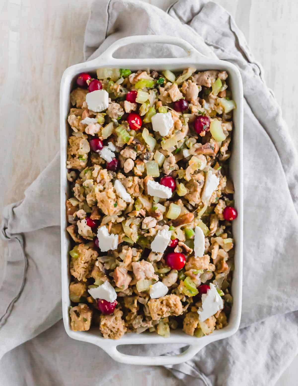 Chestnut stuffing in a baking dish dotted with butter to be baked.