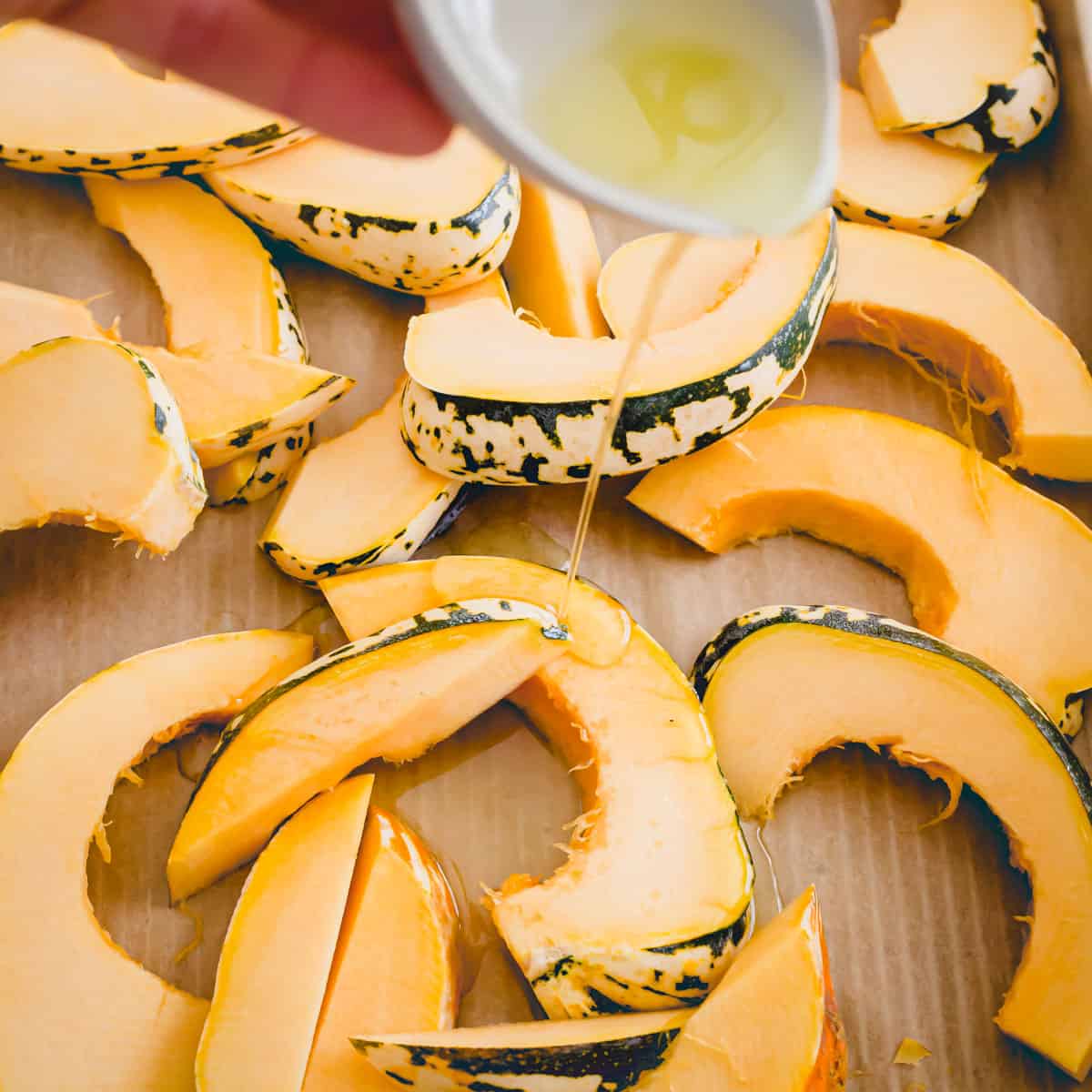 Sliced sweet dumpling squash on a baking sheet.