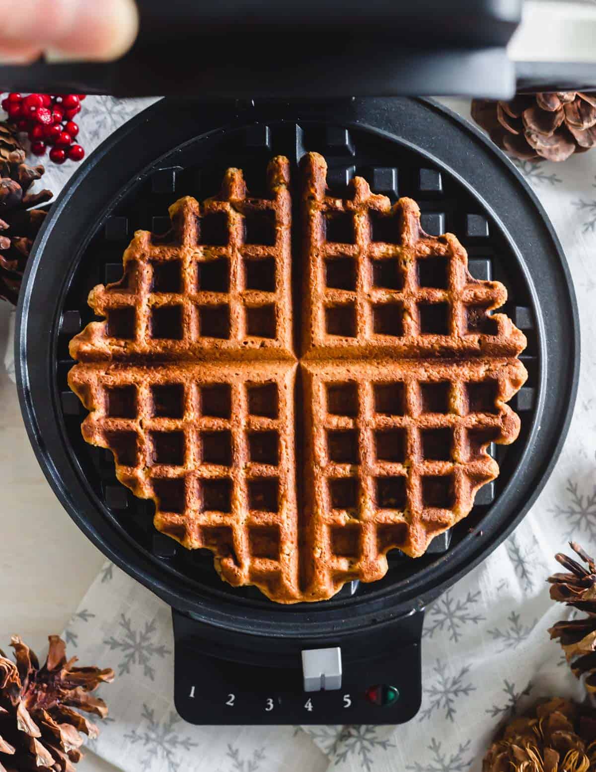 Gingerbread waffle in a waffle iron.