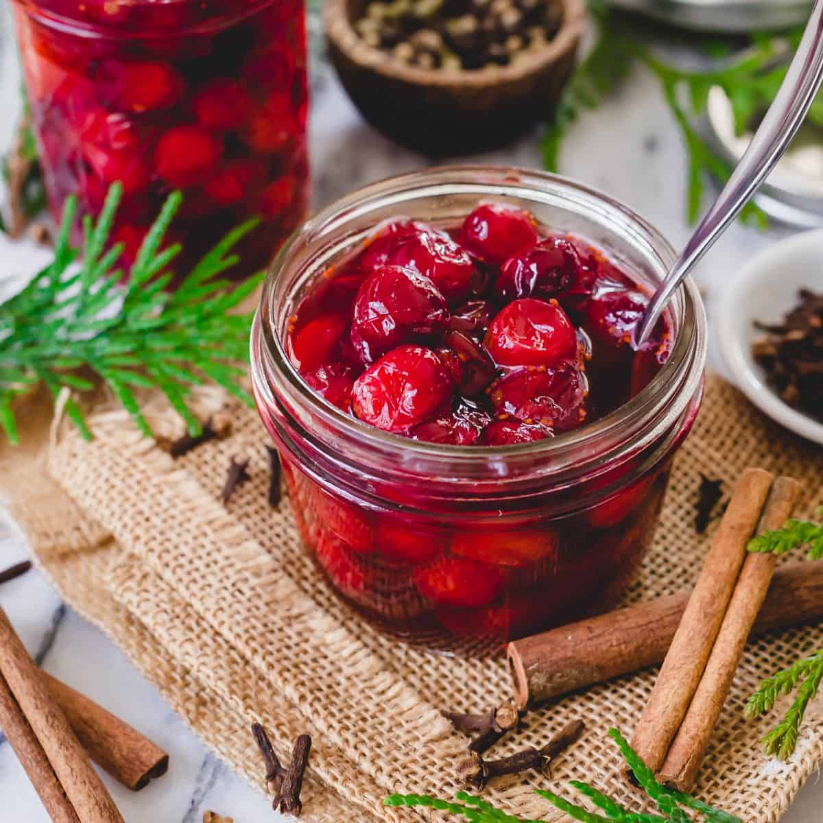 Sweet and tart pickled cranberry recipe in glass jars.