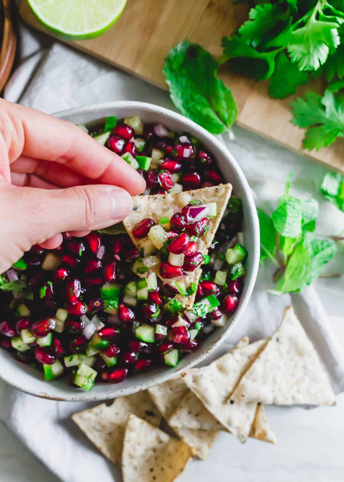 Dipping tortilla chips into pomegranate salsa.