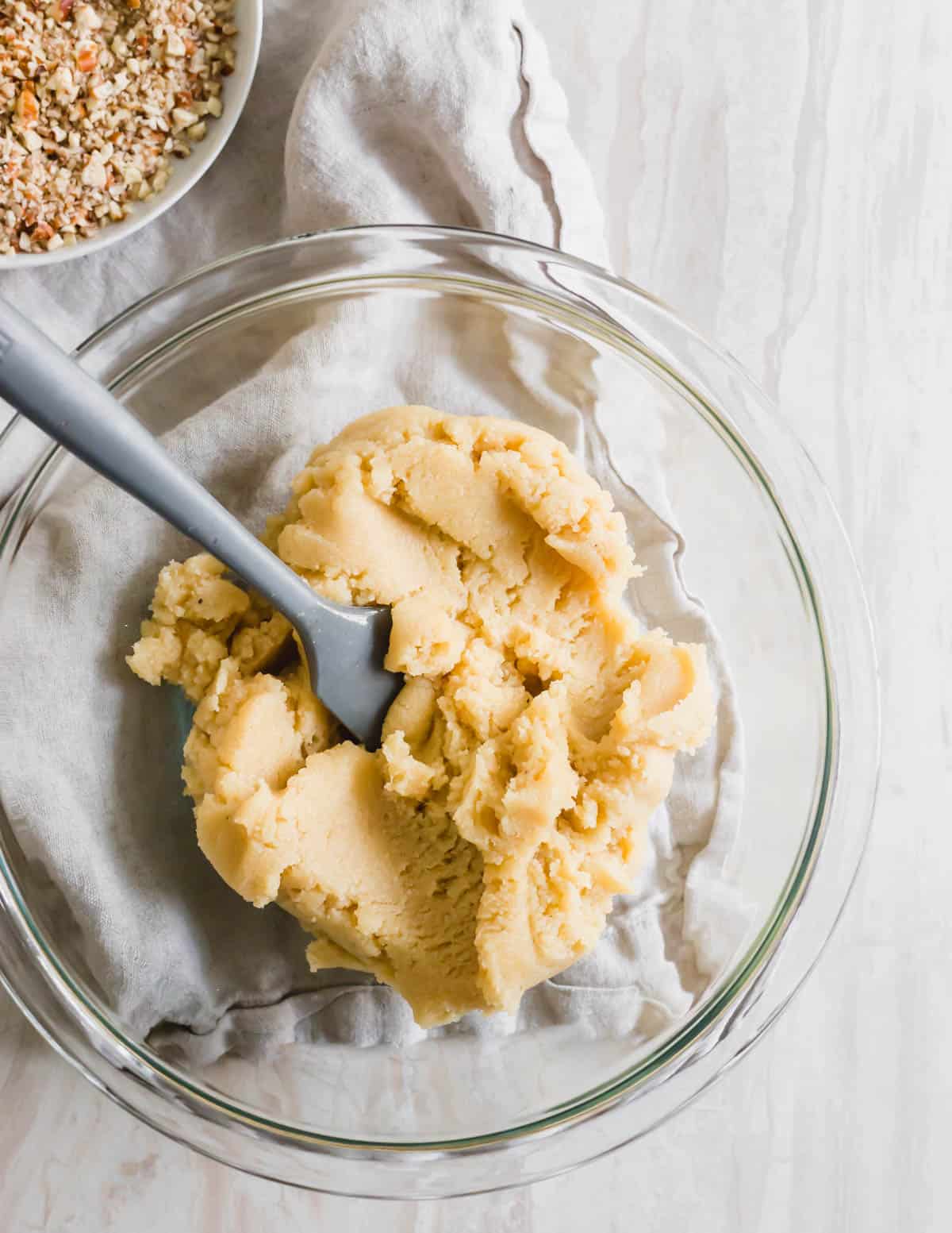 Vegan thumbprint cookie dough in a bowl with spatula.