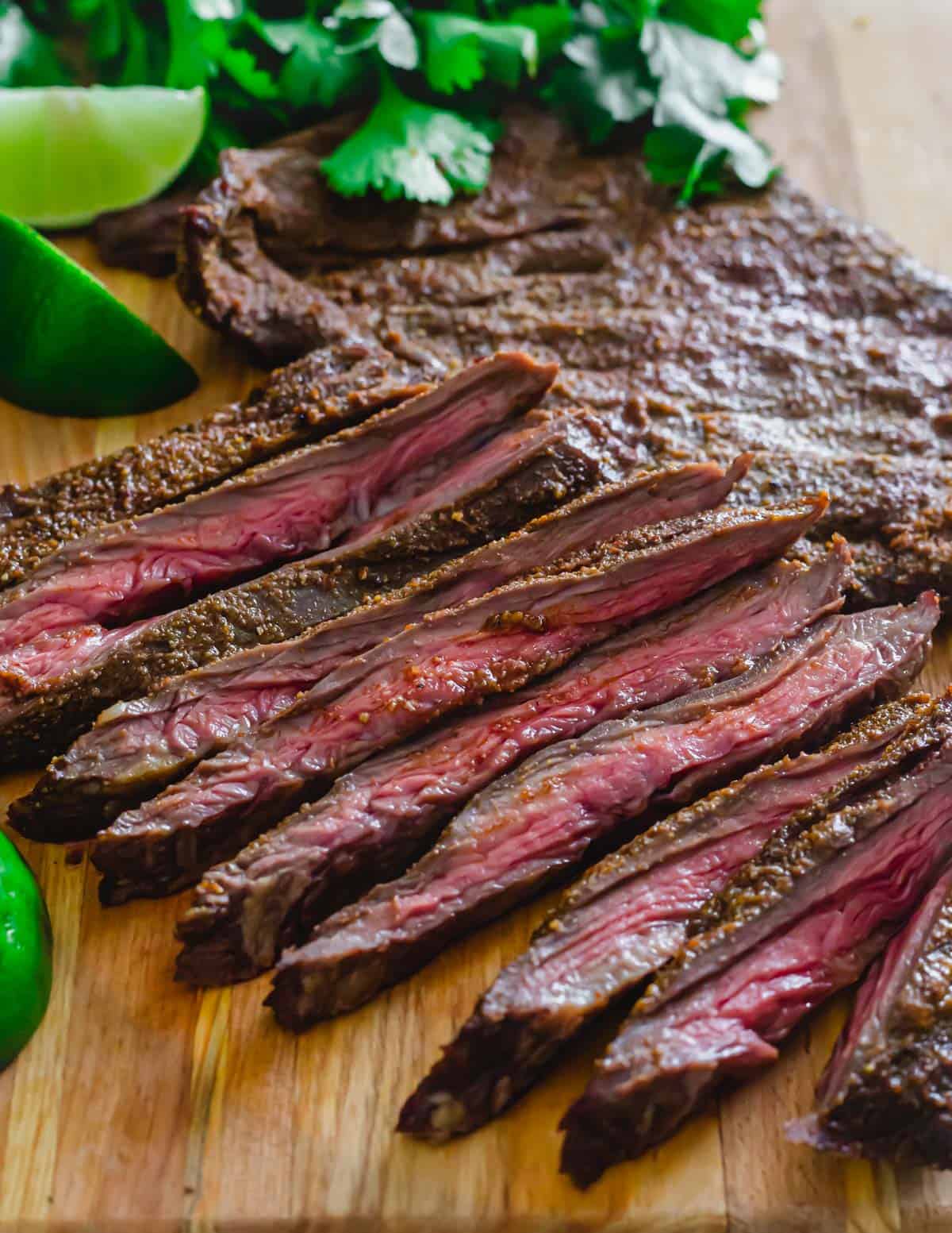 Sliced medium-rare skirt steak on a cutting board.