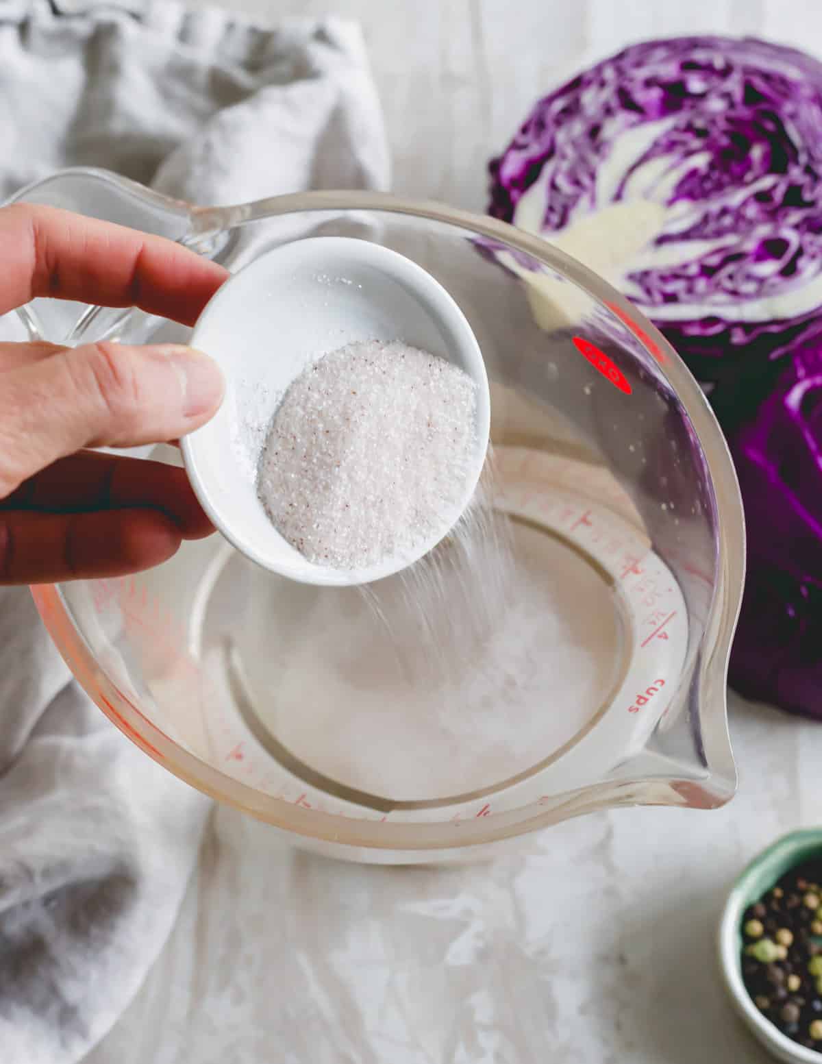 Pouring mineral salt into a measuring cup of water.