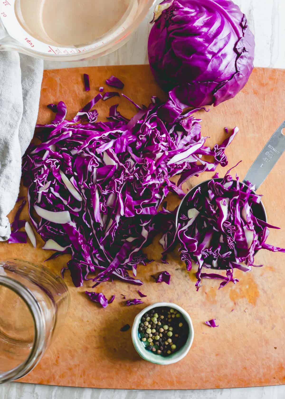Thinly sliced red cabbage on a cutting board.