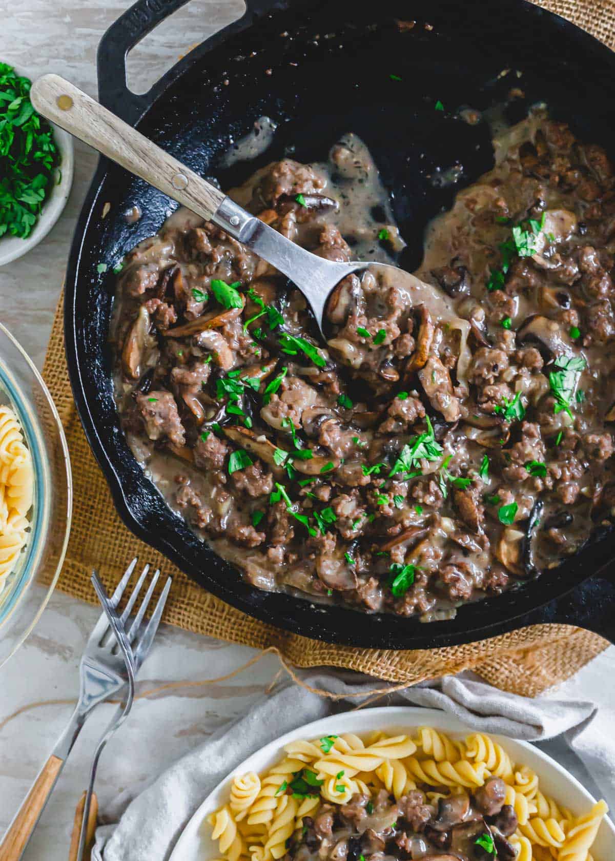 Ground venison stroganoff in a cast iron skillet with spoon.
