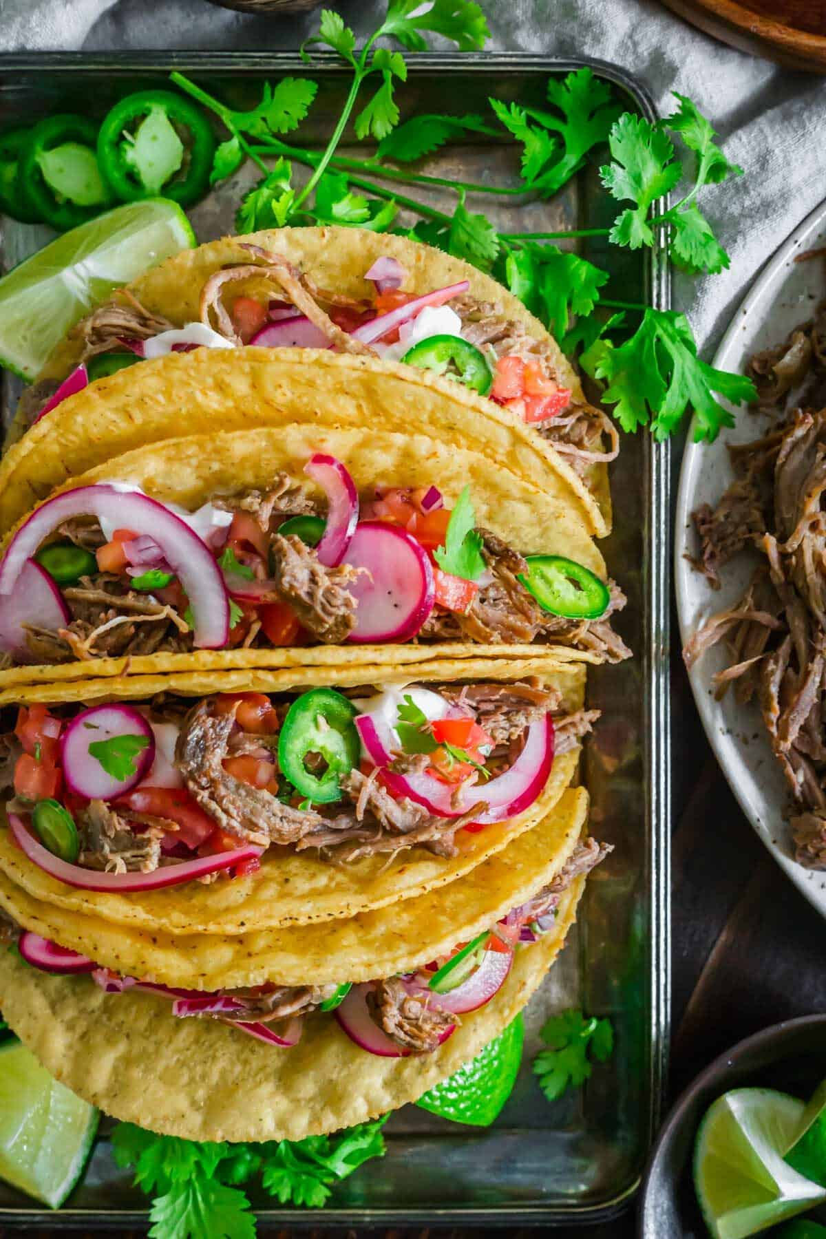 Lamb tacos with toppings in hard taco shells.