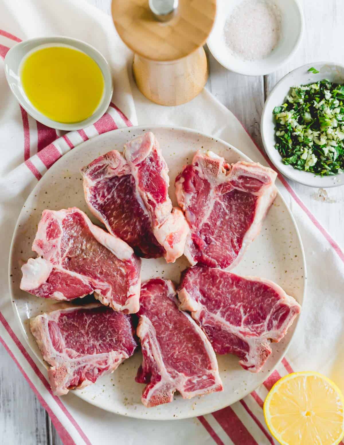 Lamb loin chops on a plate with marinade ingredients on the side.