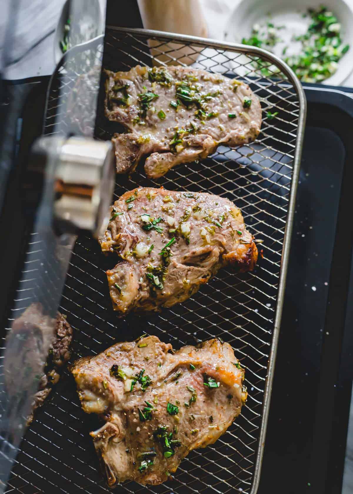 Air fryer lamb chops on rack.