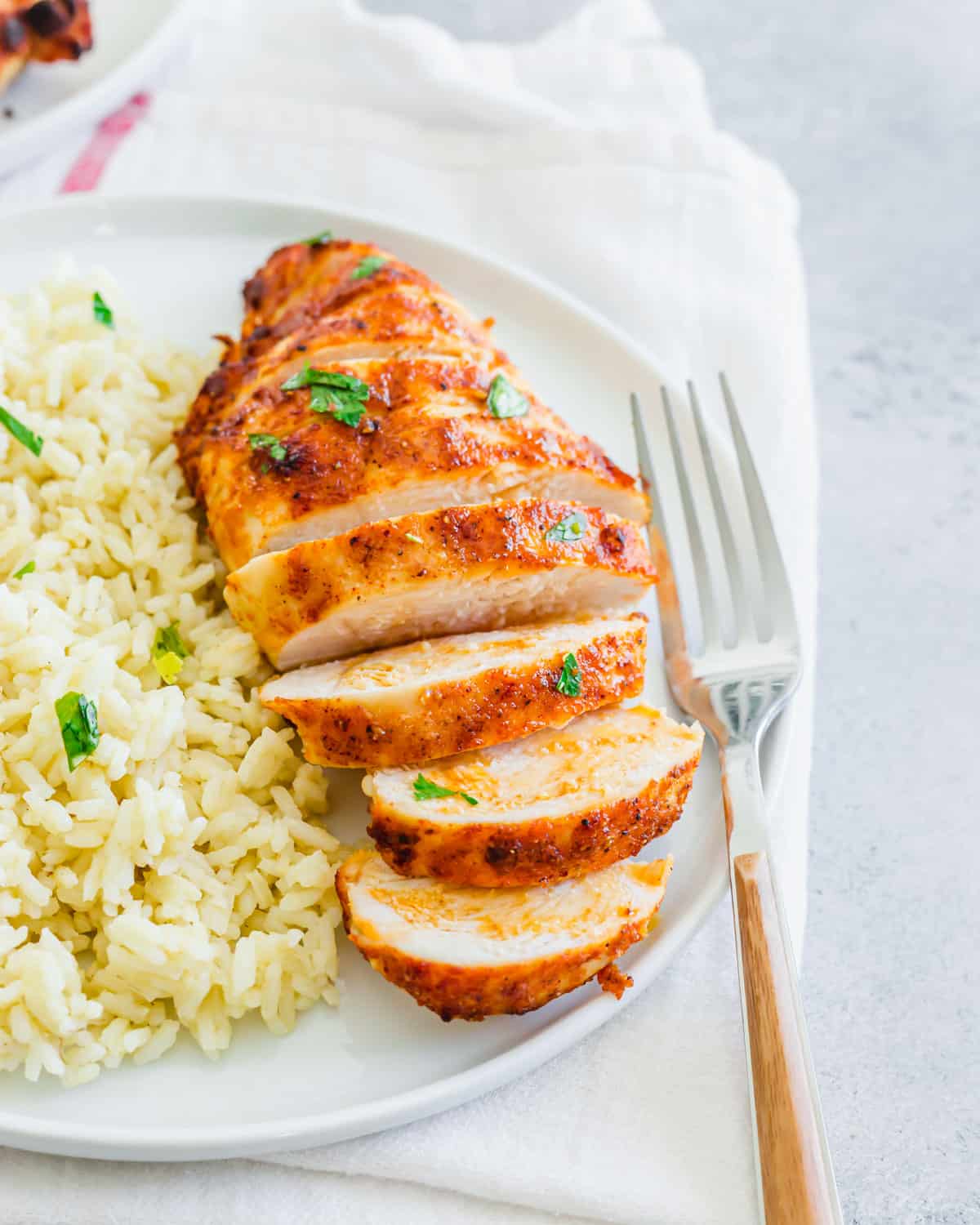 Air fryer frozen chicken breast recipe with simple seasoning served on a plate with rice.