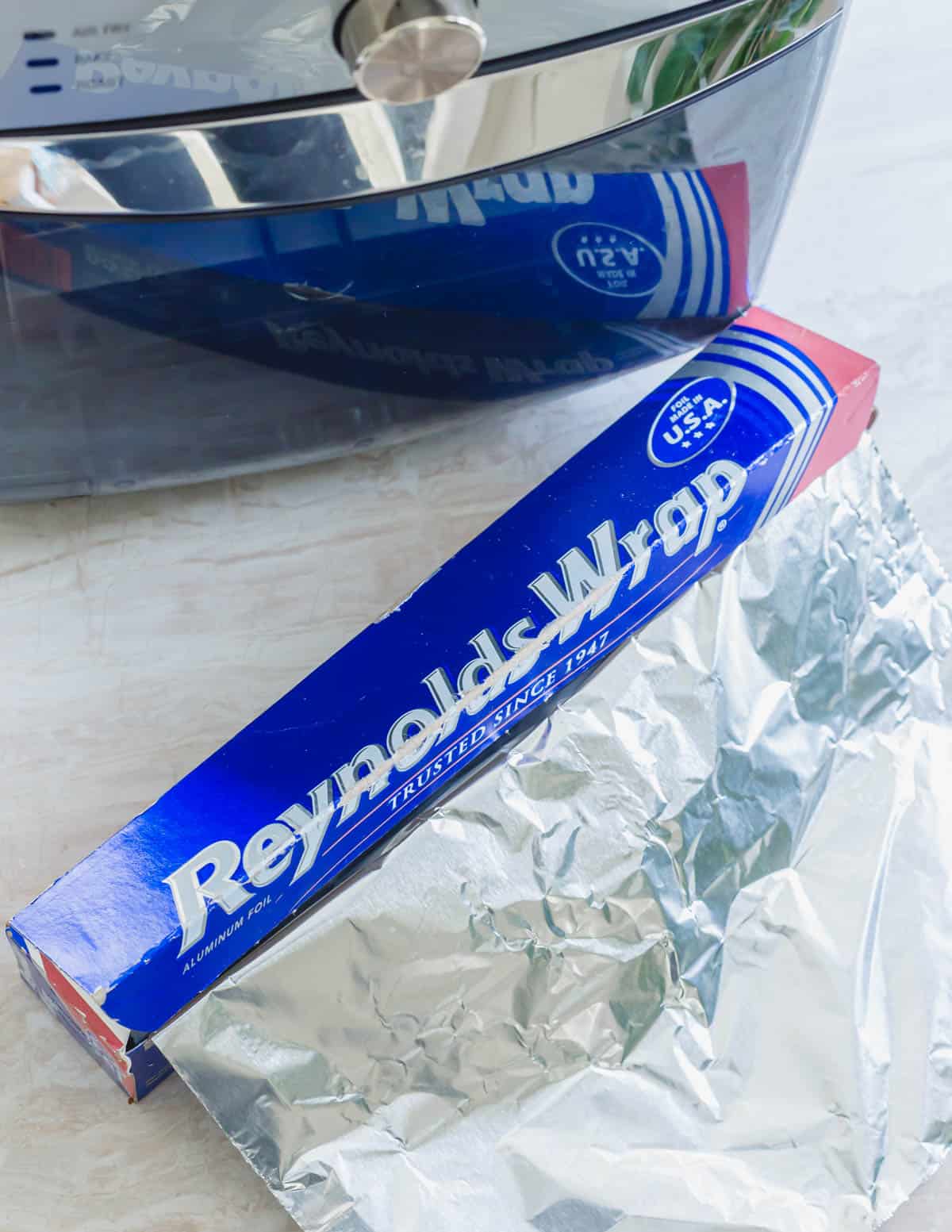 Reynold's Wrap aluminum foil next to an air fryer.