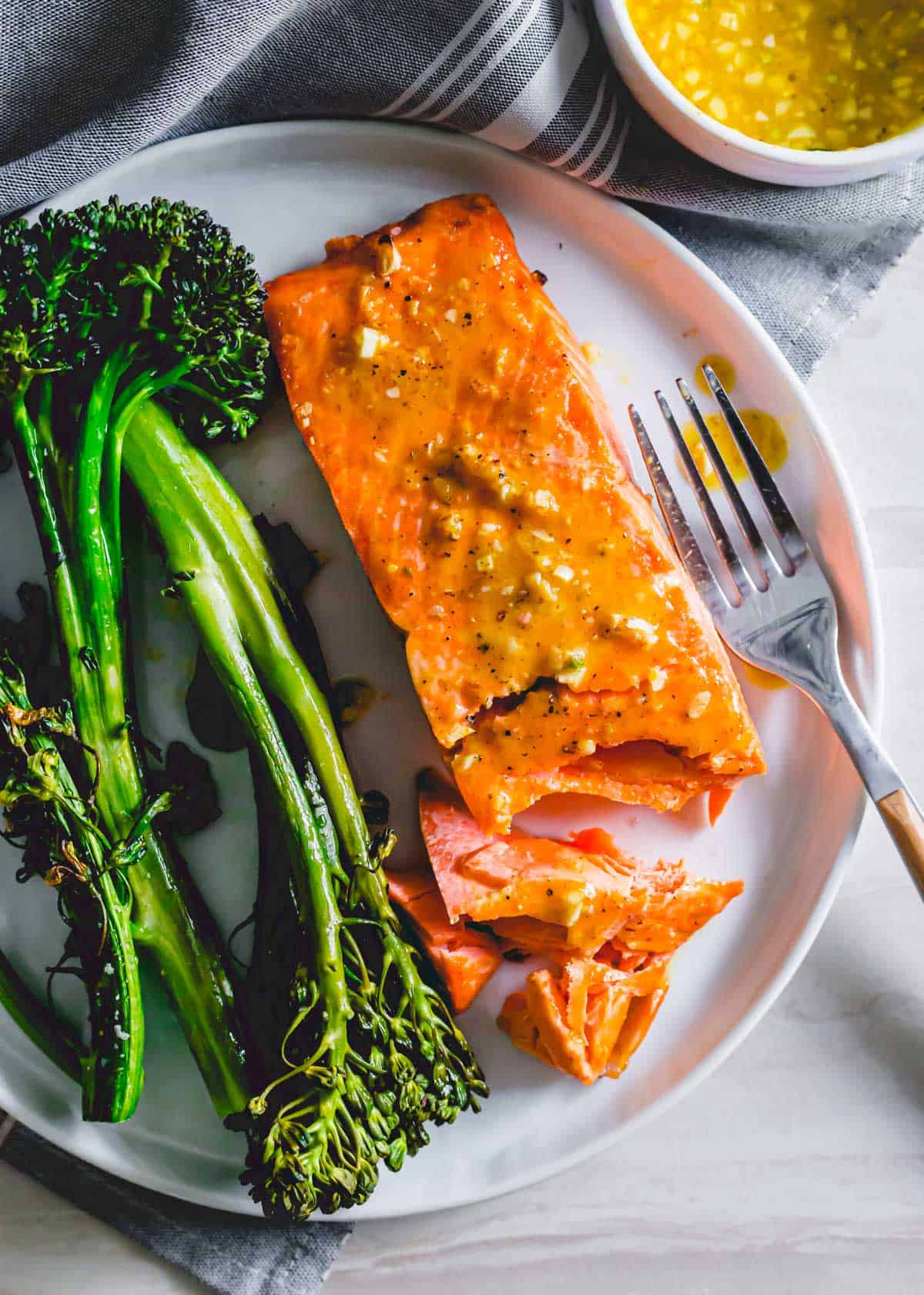 Air Fryer Frozen Salmon with maple mustard sauce on a plate with roasted broccolini.