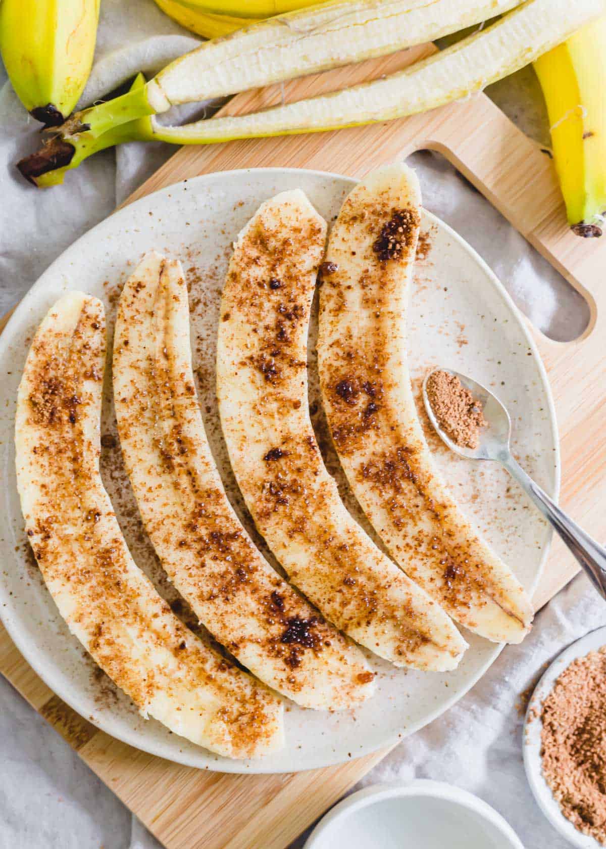 Cinnamon sugar coated banana halves on a plate.