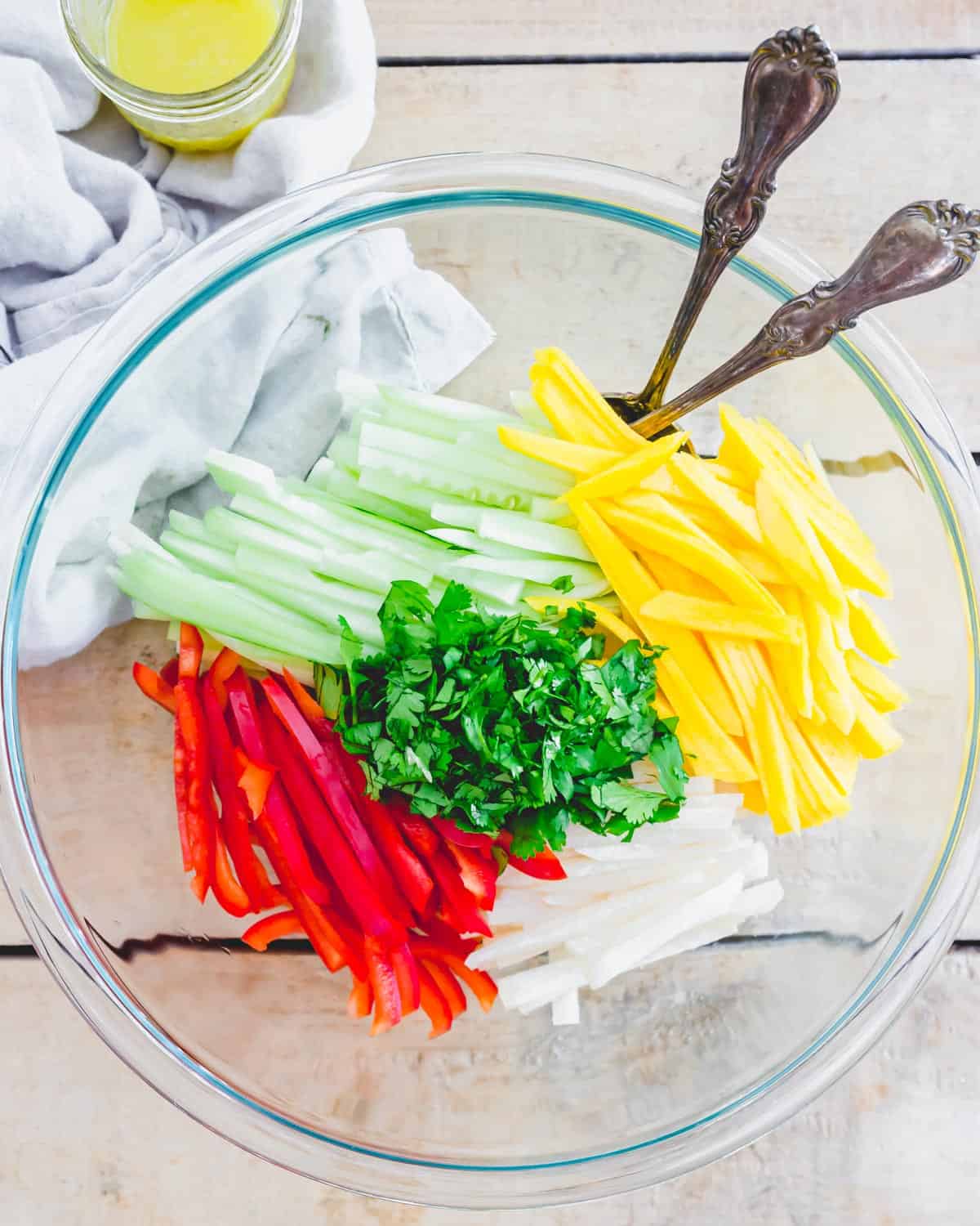 Ingredients to make jicama salad in a large glass bowl.