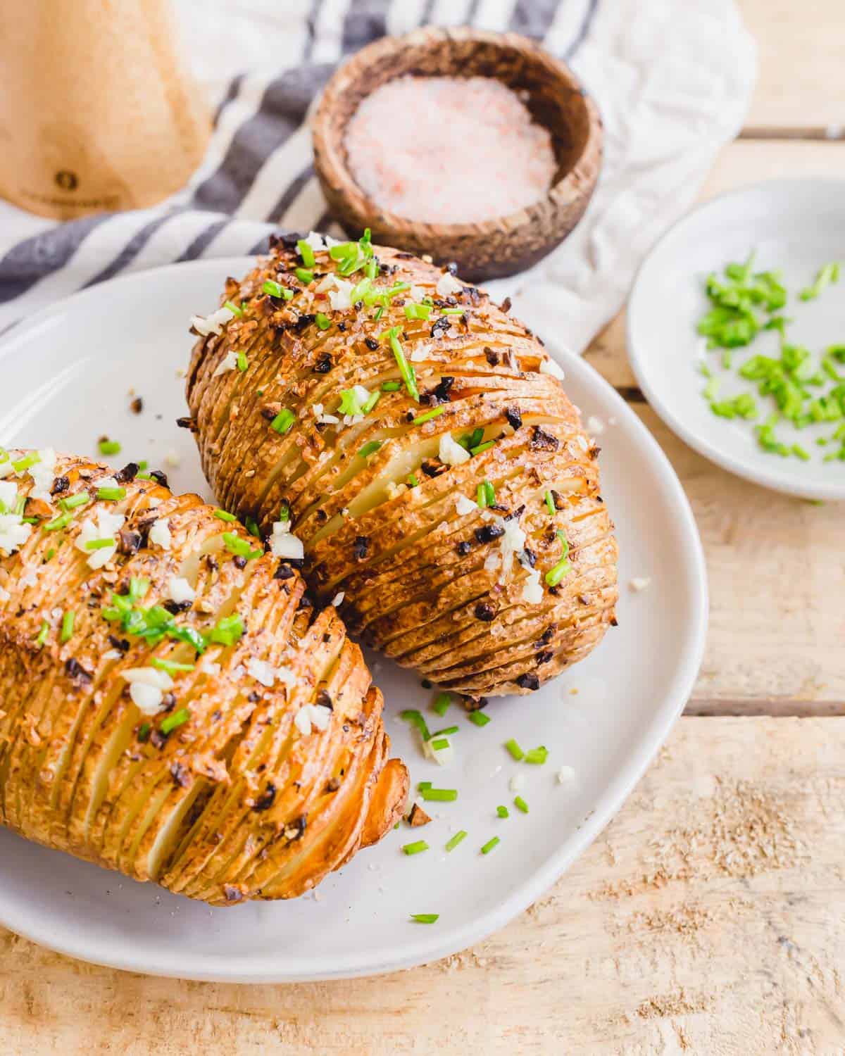 Crispy golden brown hasselback white potatoes on a plate.