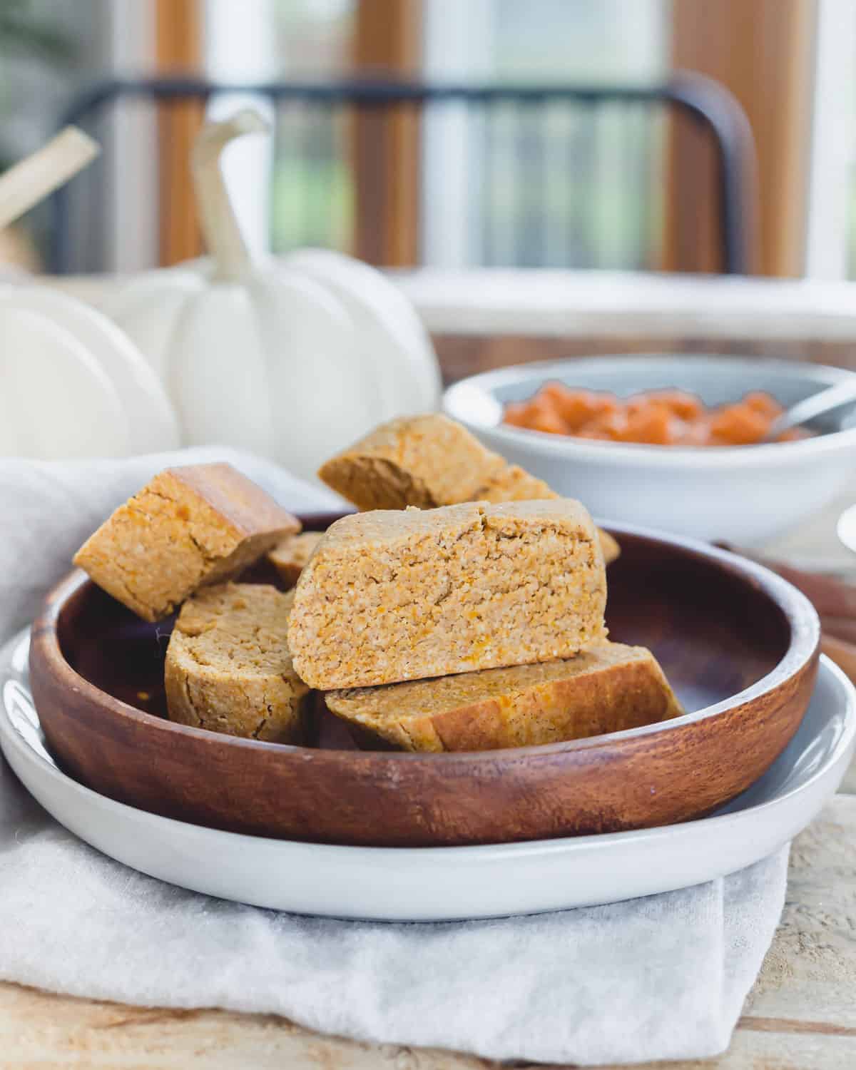 Pumpkin biscotti recipe on a plate atop a wooden table setting.