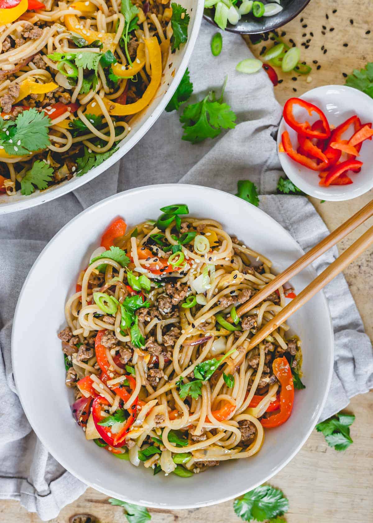 Spicy udon noodle recipe in a white bowl with chopsticks.