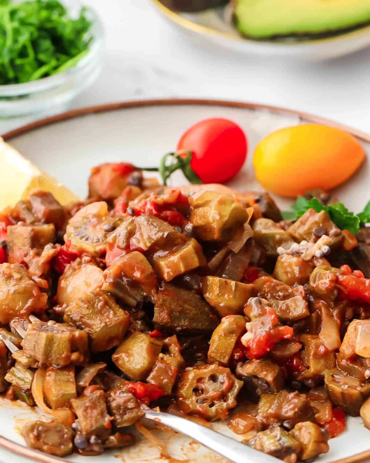 Stewed okra and tomato recipe on a plate with a serving fork.