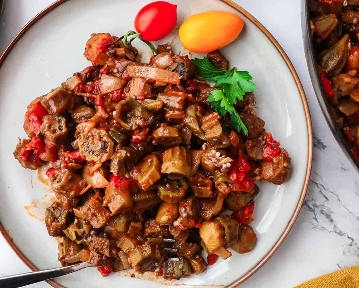 Southern okra and tomato recipe on a serving plate with a fork.