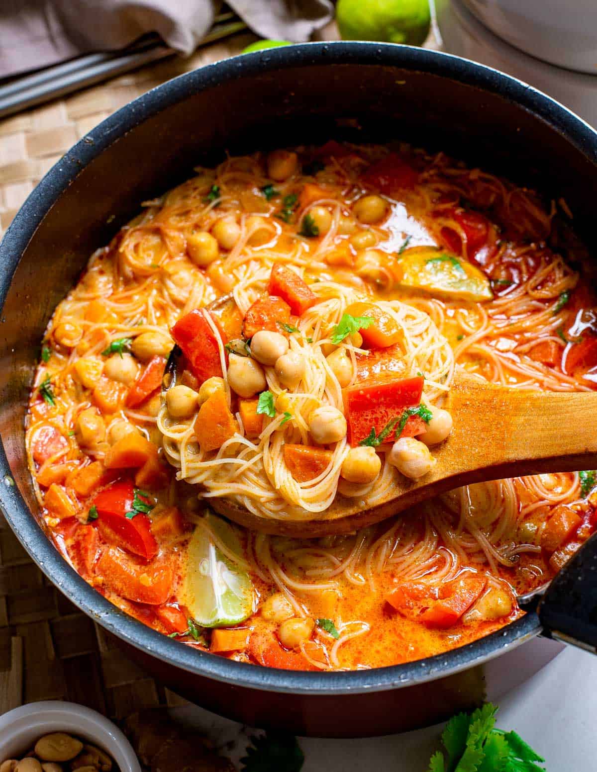 Gluten-free red curry Thai noodle soup with chickpeas in a soup pot.