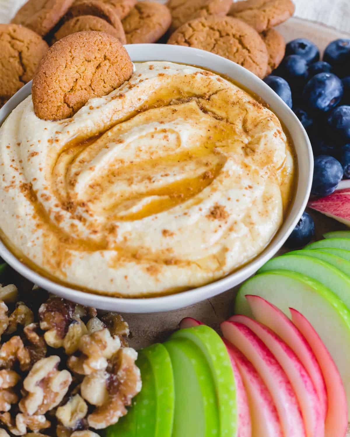 Pumpkin ricotta dip in a bowl with a gingersnap cookie.