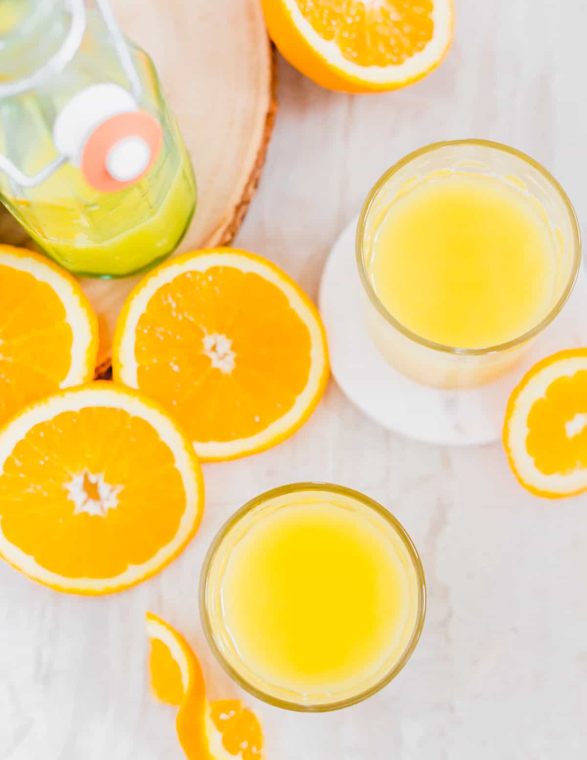 An adrenal drink in glasses with orange slices next to it.