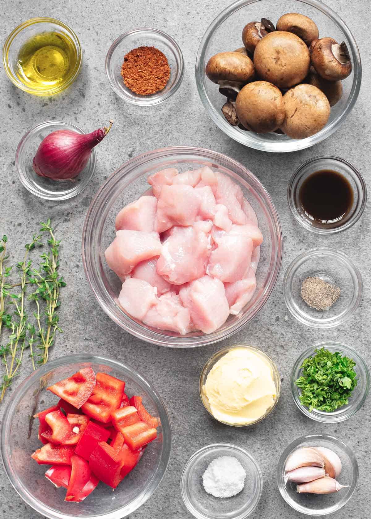 Ingredients to make chicken bites in glass bowls on a gray background.