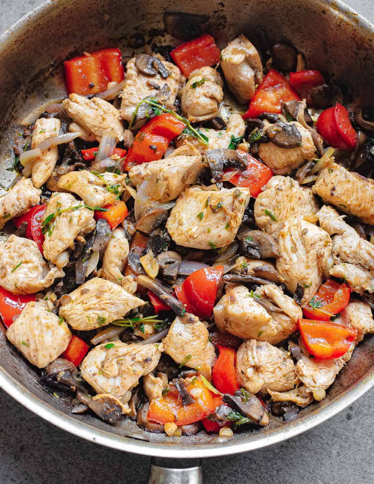 Garlic chicken bite recipe with thyme, onions, mushrooms and red peppers.