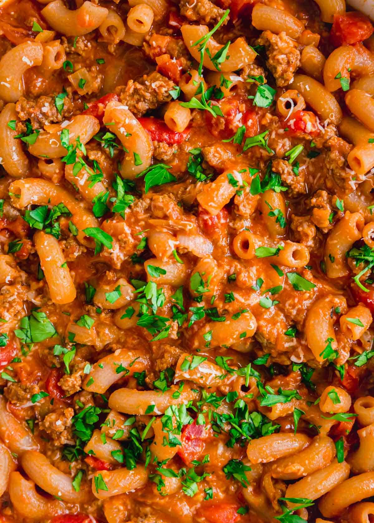 Ground beef pasta garnished with parsley and cheese.