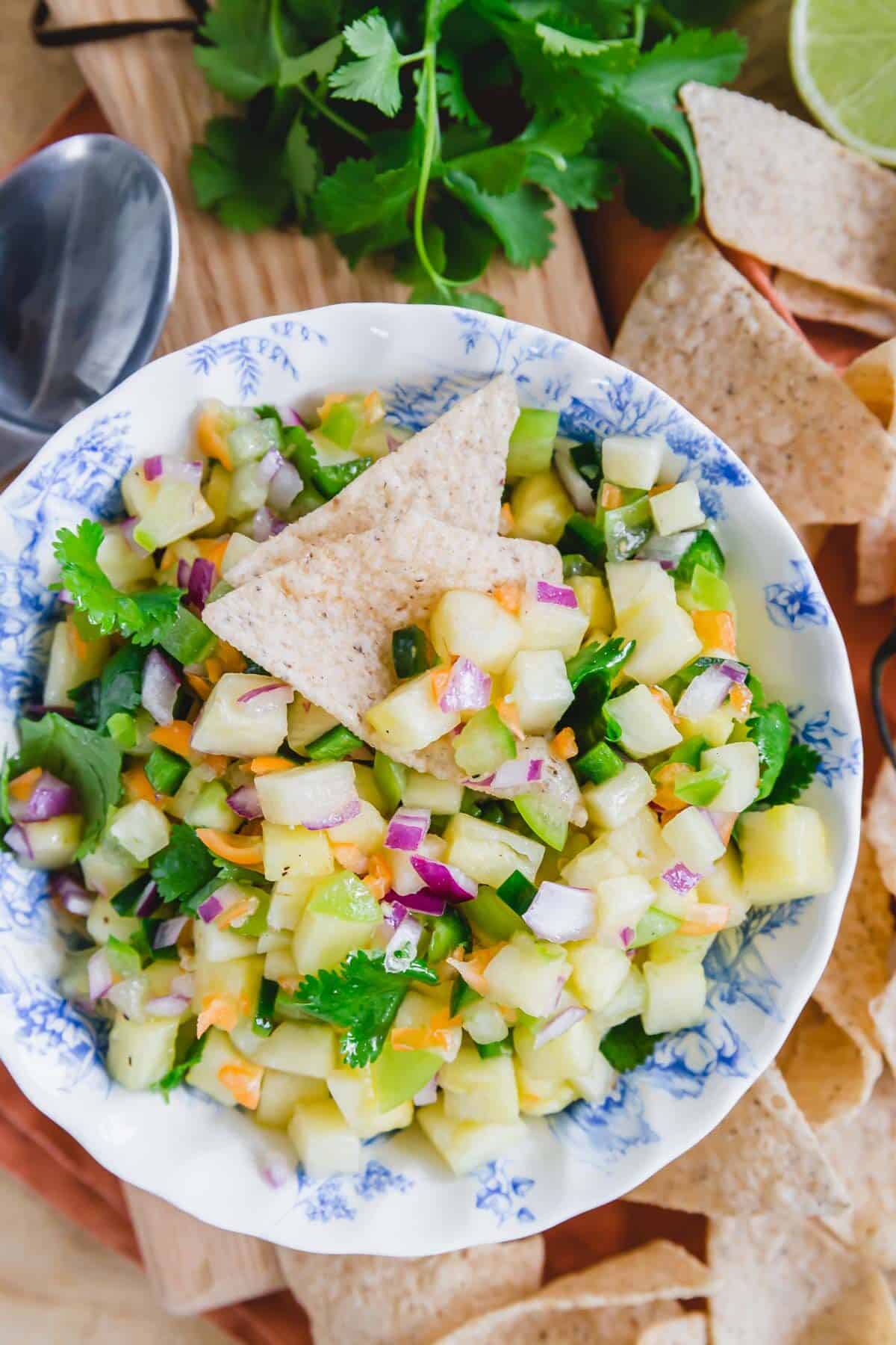 Pineapple habanero salsa in a bowl with a tortilla chip.