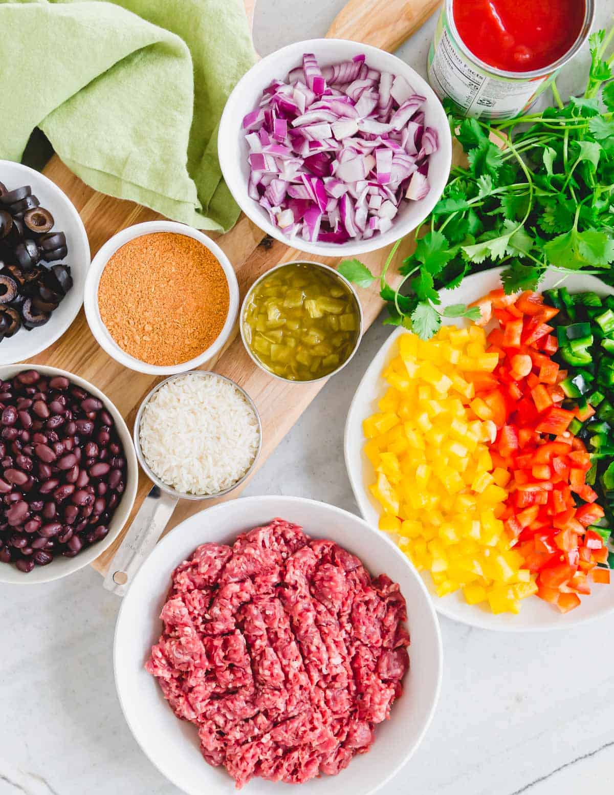 Ingredients to make a Mexican ground beef recipe in a skillet.