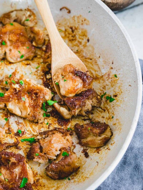 Lion's Mane mushrooms in a pan with a wooden spoon.