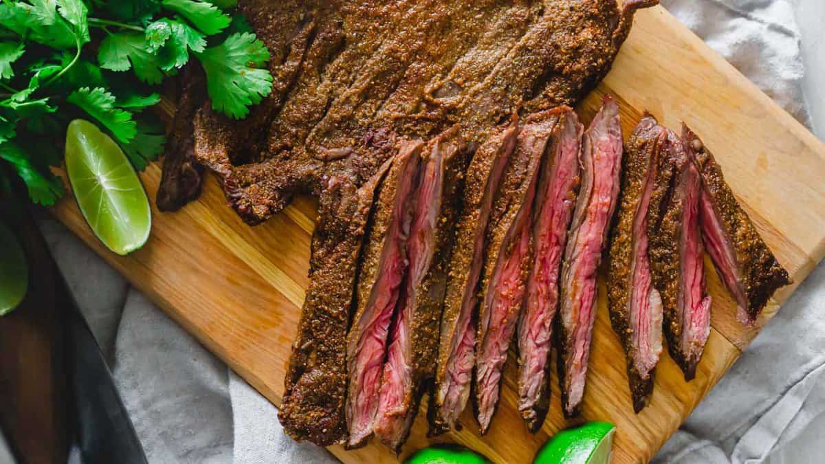 Air fryer skirt steak sliced on a cutting board.