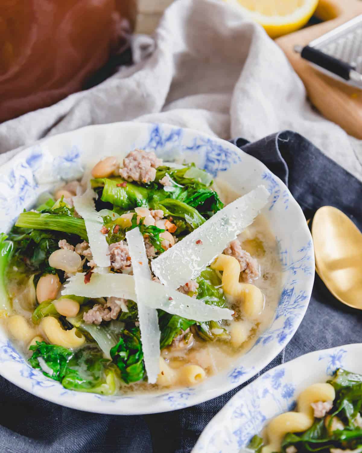 Escarole soup topped with shaved parmesan and red pepper flakes. Escarole soup topped with shaved parmesan and red pepper flakes.