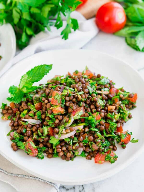 Lentil tabbouleh garnished with mint served on a white plate.