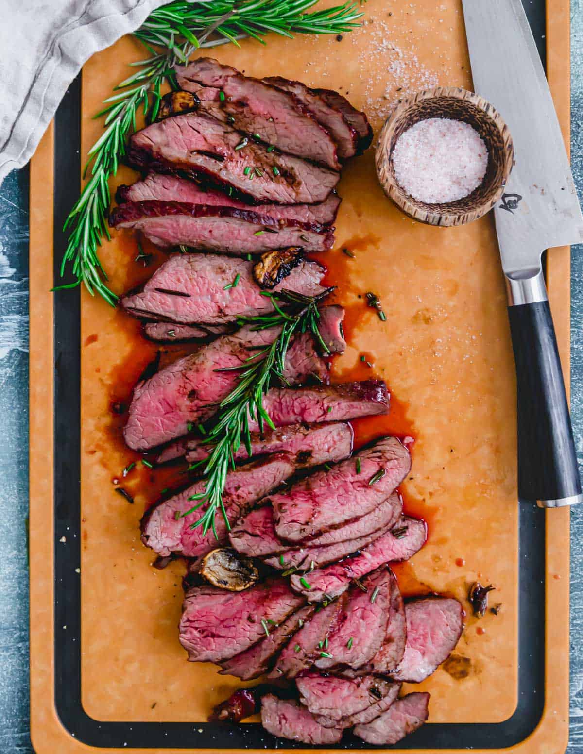 Reverse sear tri tip steak cut on the bias on a cutting board.
