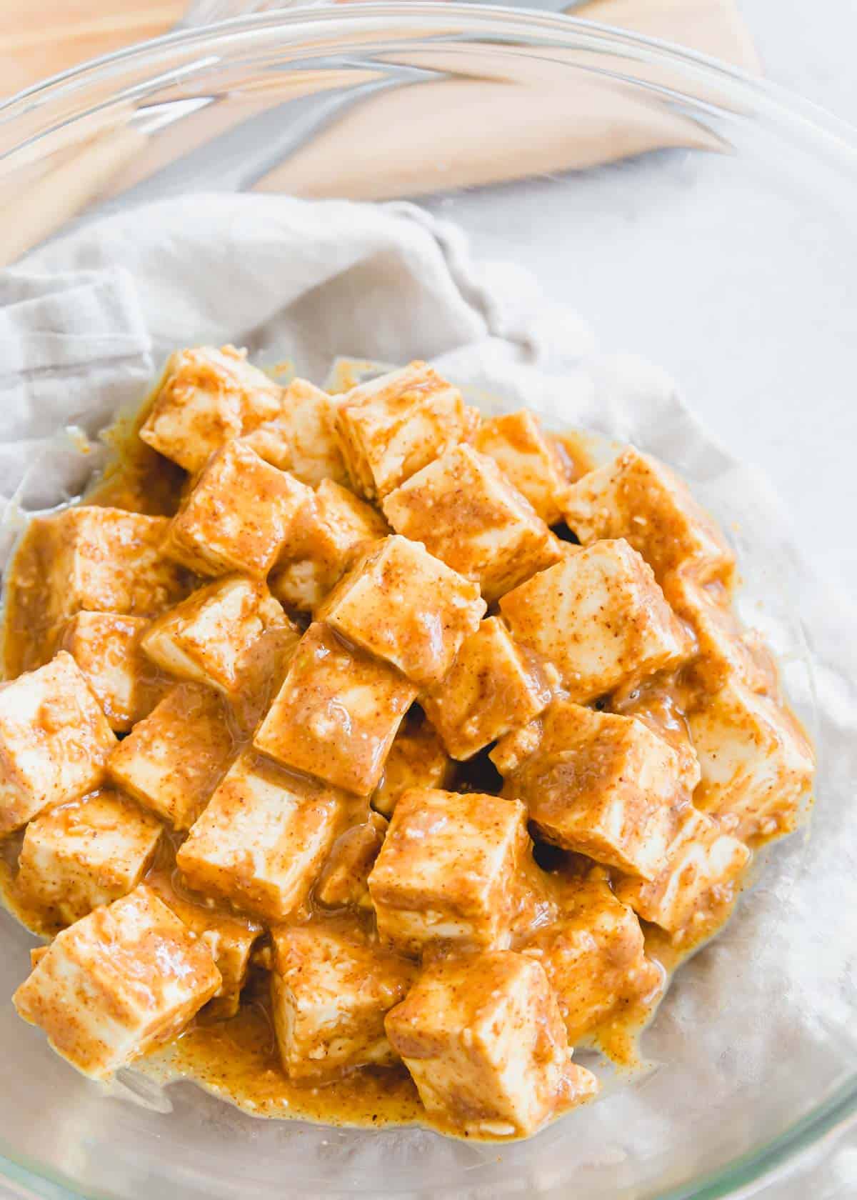 Cubed extra firm tofu marinating in a creamy almond butter, ginger, garlic and lime sauce.