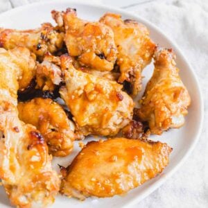 Marinated baked chicken wings on a plate.