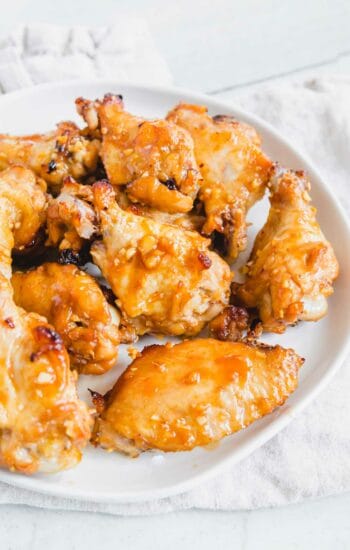Marinated baked chicken wings on a plate.