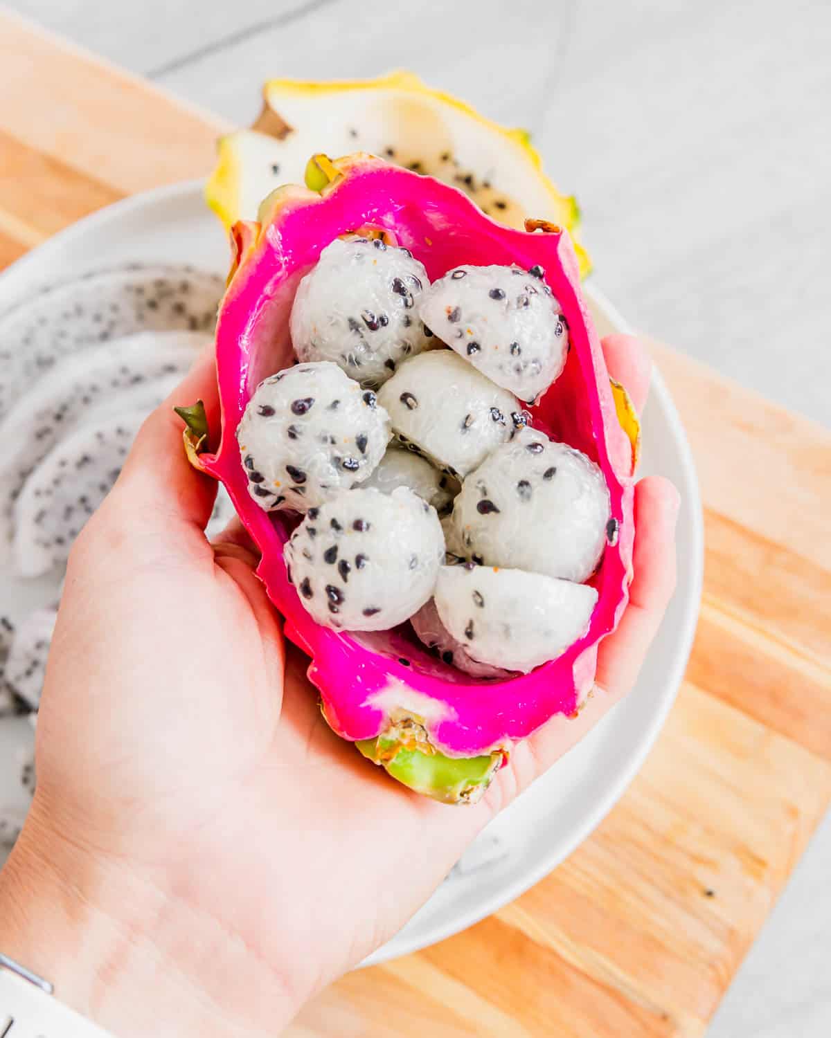 Dragonfruit balls inside half a pink dragonfruit peel.