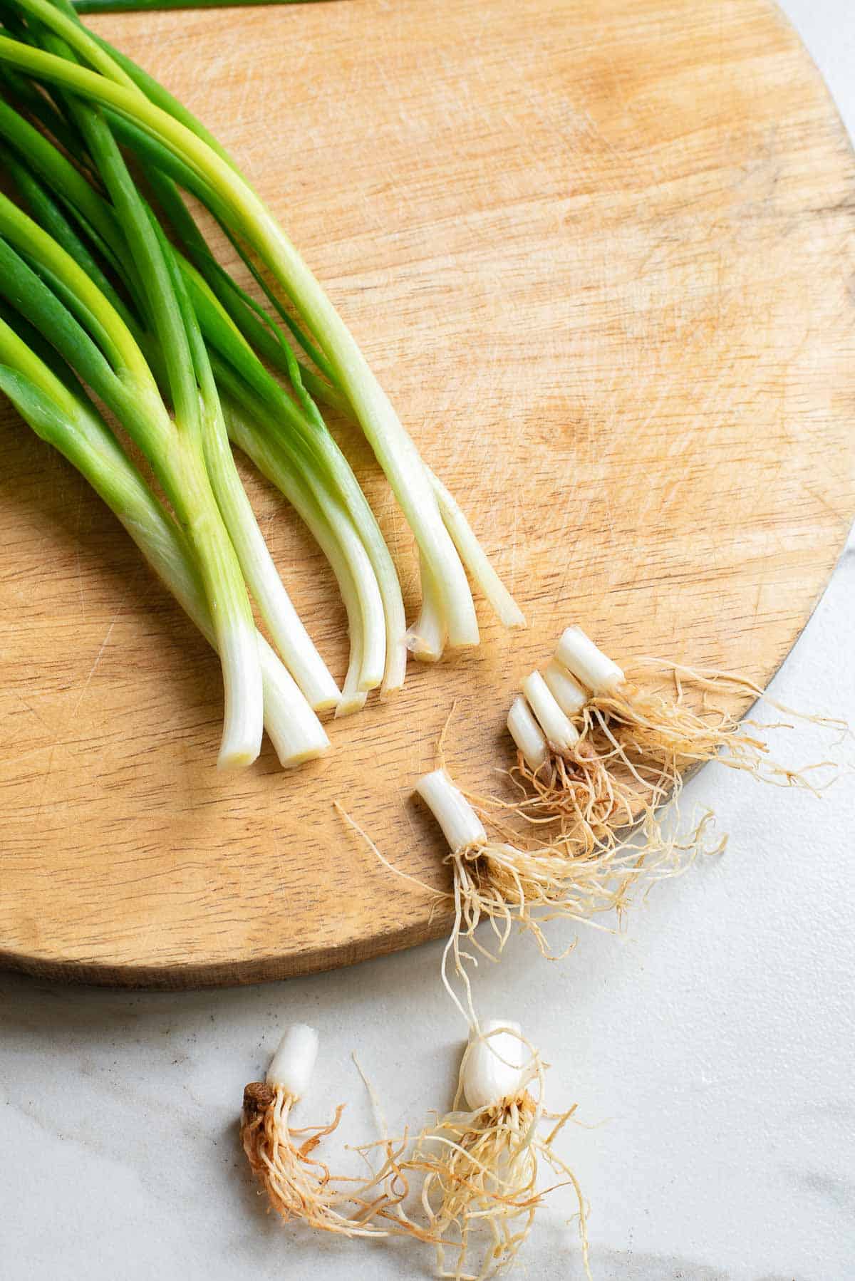 Chopping off the ends of a bunch of scallions.