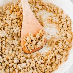 Fully cooked seasoned ground turkey meat in a skillet with a spatula.