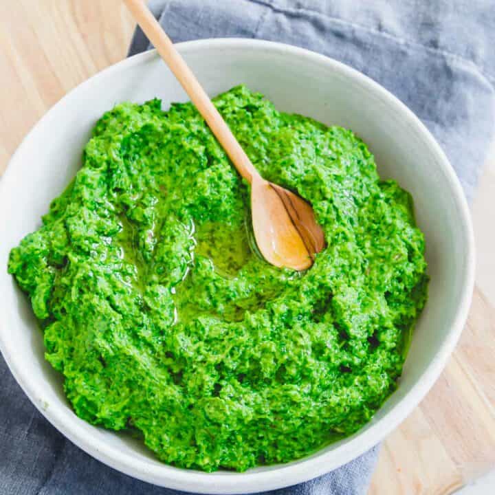 Fresh ramp pesto recipe in a bowl with a little wooden spoon.