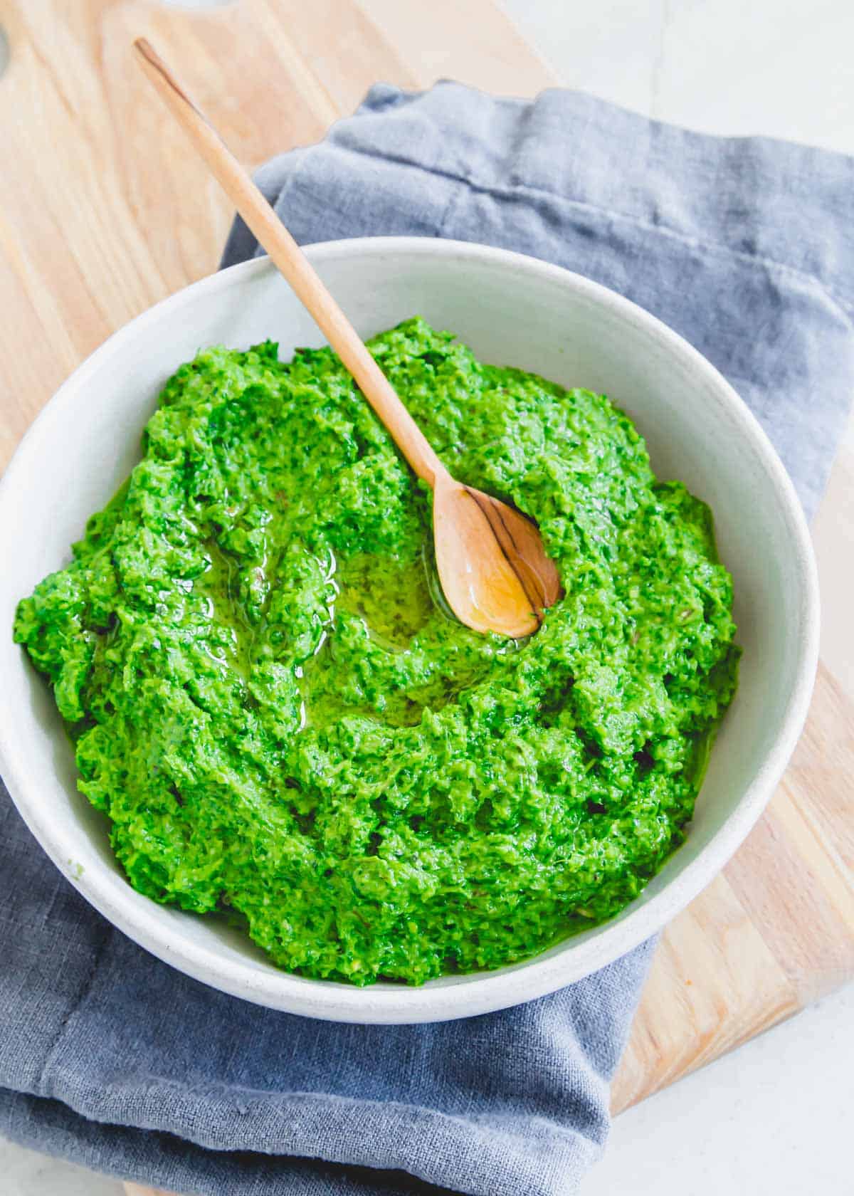 Fresh ramp pesto recipe in a bowl with a little wooden spoon.