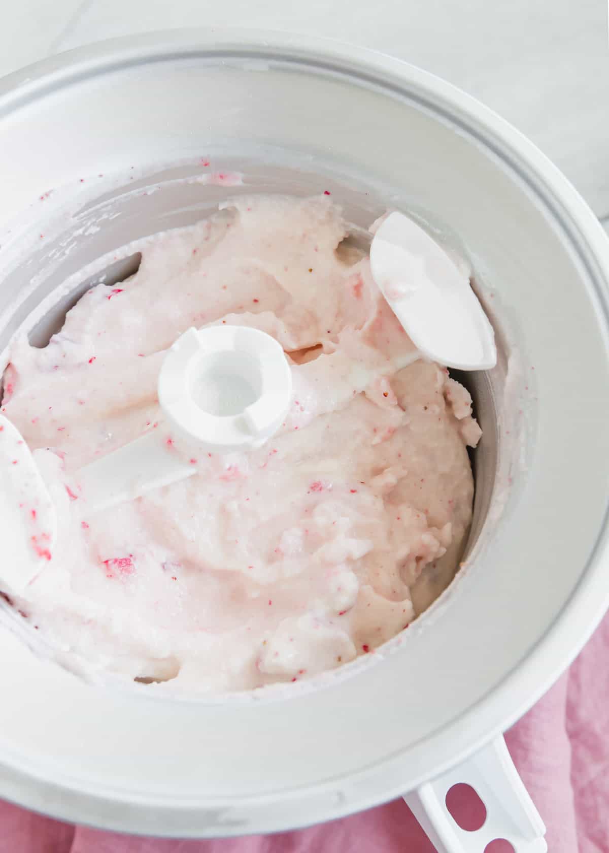 Strawberry kefir ice cream in the ice cream maker.