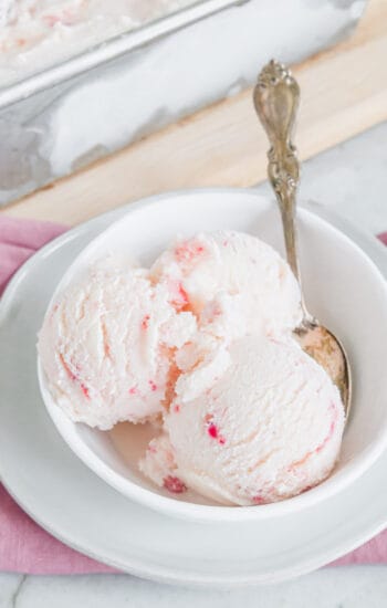 Strawberry vanilla kefir ice cream in a white bowl with a spoon.