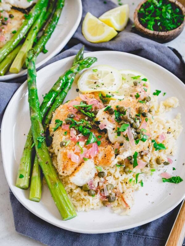 Cod piccata plated with rice and asparagus.