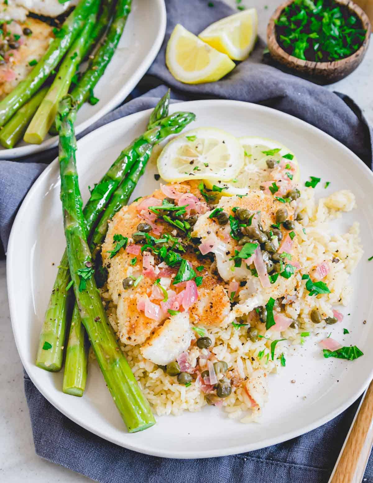 Cod piccata plated with rice and asparagus.